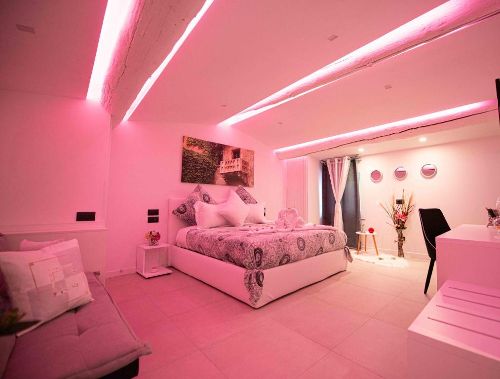 维罗纳HOME CARPEDIEM的粉红色的卧室配有床和沙发