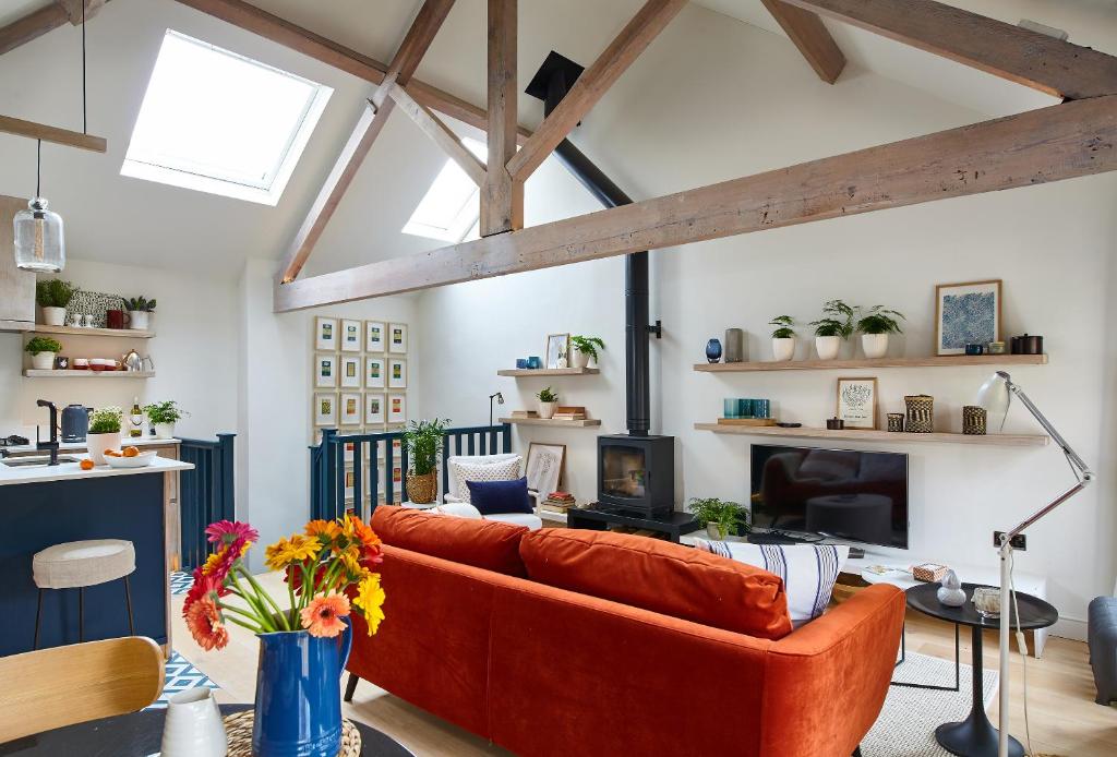 巴斯The Loft House - Beautiful House in Best Location的客厅配有橙色沙发和壁炉