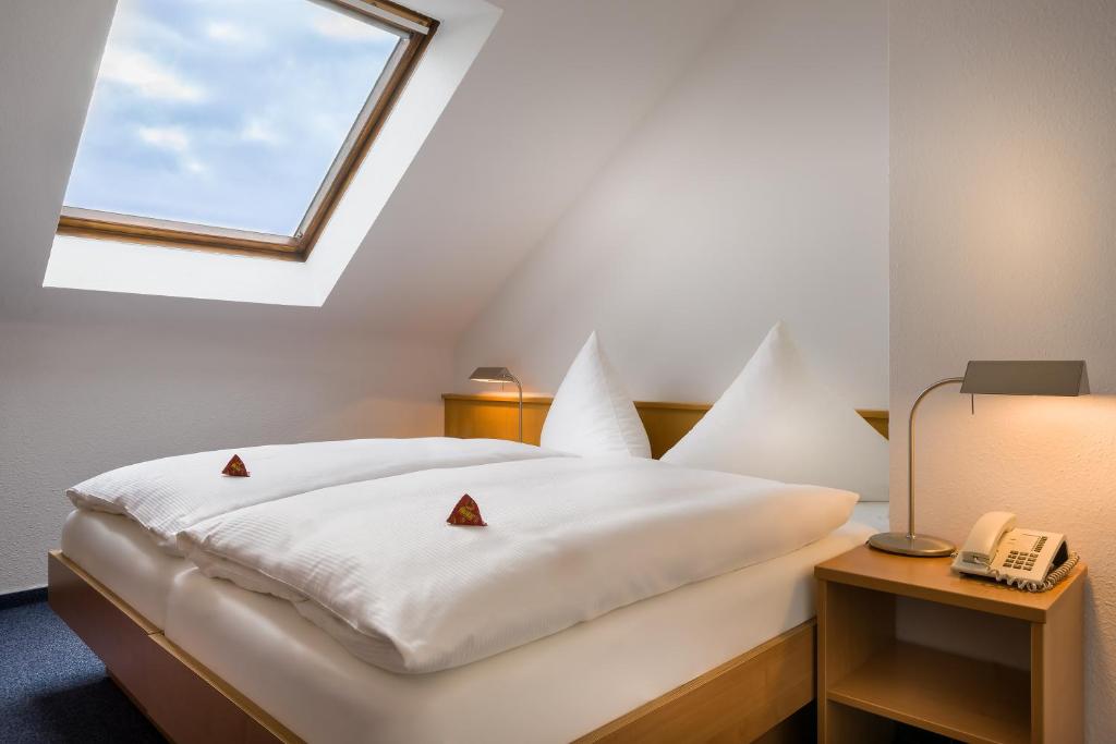 卡尔斯鲁厄acora Karlsruhe Zentrum Living the City - Apartments的卧室配有白色的床和窗户