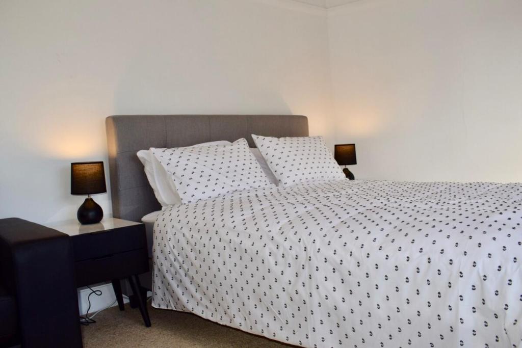 悉尼Cosy 3 Bedroom Apartment In Trendy Haberfield的卧室配有一张白色床,桌子上放着两盏灯