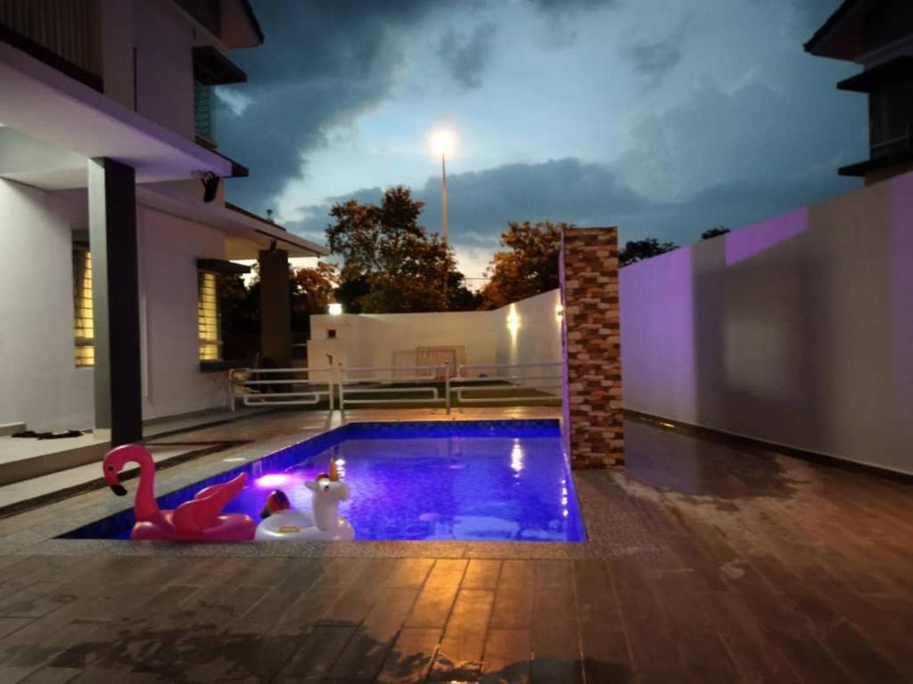 汝来Villa with private Pool and Sauna @ Nilai的一座带两个玩具火烈鸟的游泳池