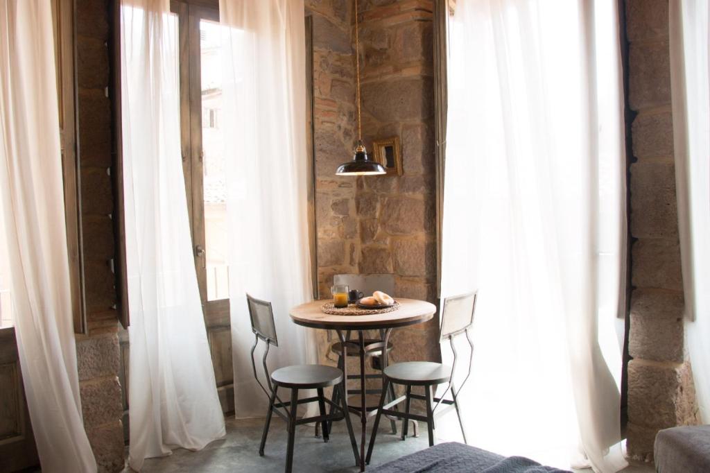 卡尔多纳Casa Boutique nº 24的一张小桌子,位于一间白色窗帘的房间的角落