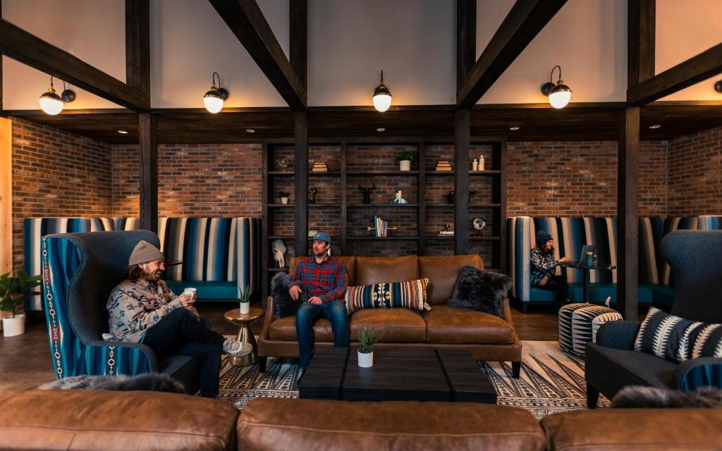 特柳赖德The Bivvi Hostel Telluride的两人坐在客厅的椅子上