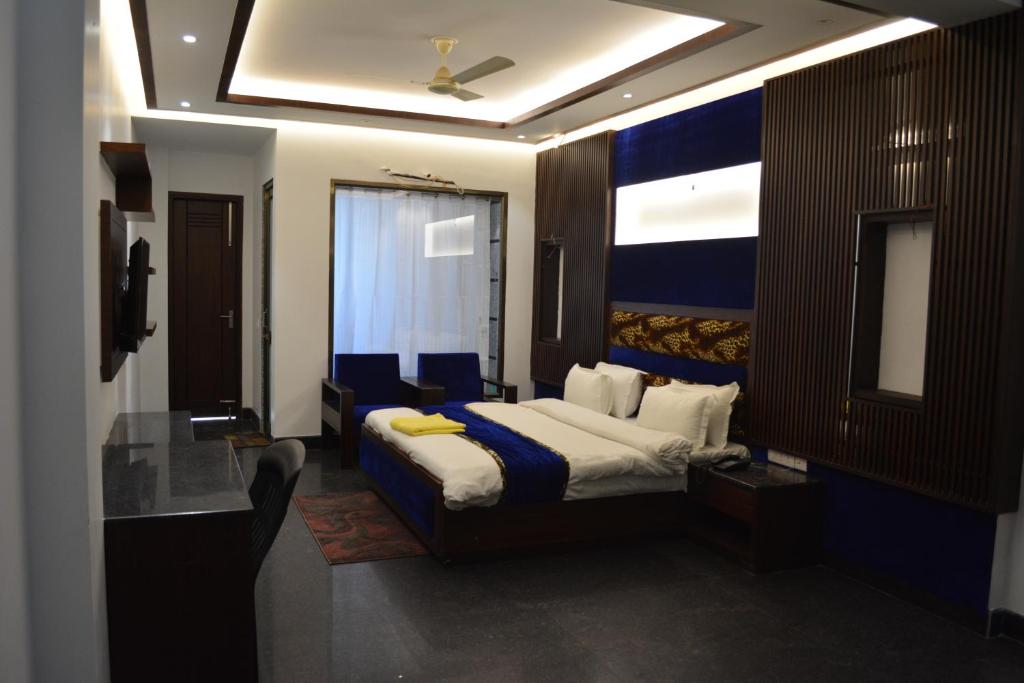 穆扎夫法尔普尔JJK Rukmini Vilas Hotel & Banquet的酒店客房的床铺配有蓝色和白色的床单