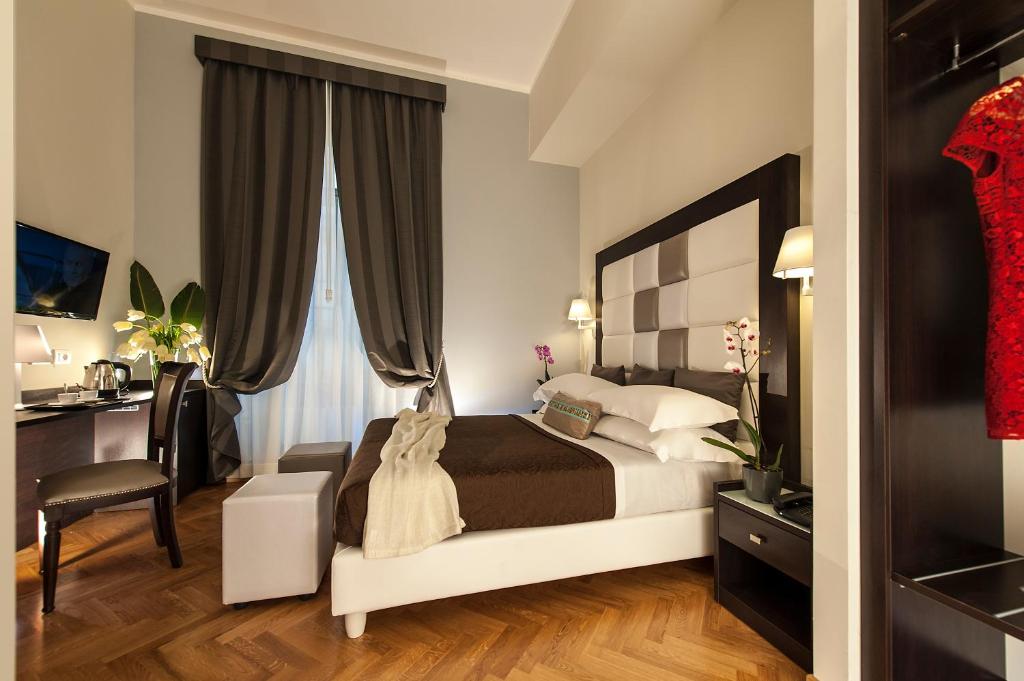 罗马罗马DVE套房酒店的一间卧室配有一张床、一张桌子和一把椅子