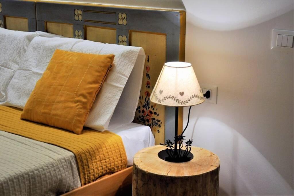费德拉帕加内拉Appartamento Dolomella的一间卧室配有一张床和一张桌子上的台灯