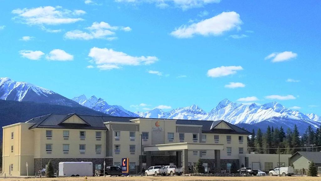 维勒蒙特Comfort Inn & Suites的一座大建筑,背景是群山