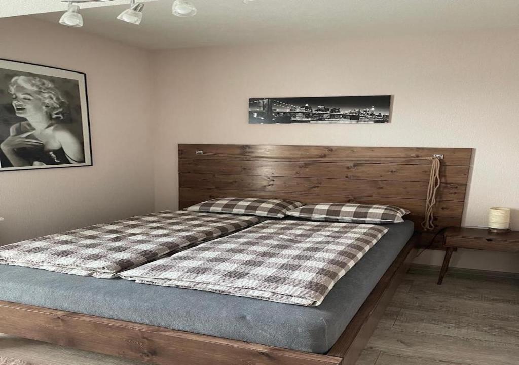 别尔斯克-比亚拉Apartamenty Bartnicza A的一间卧室配有一张带木制床头板和照片的床。
