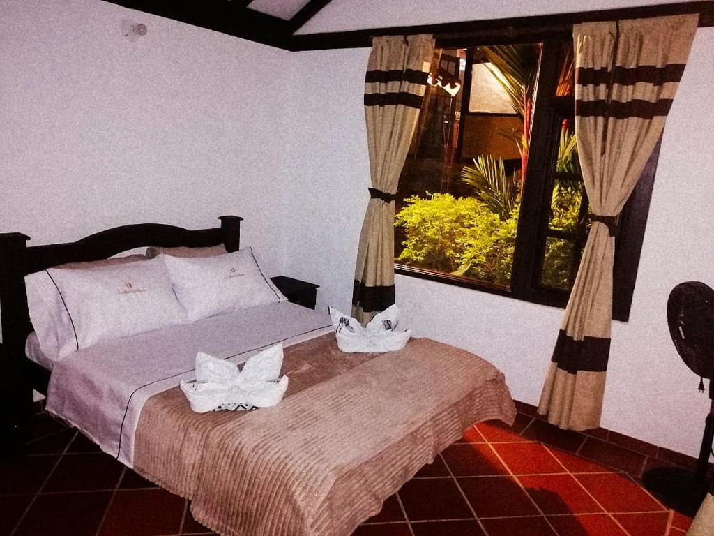 萨赛马LoMar Sol&Luna的一间卧室配有一张带两条白色毛巾的床