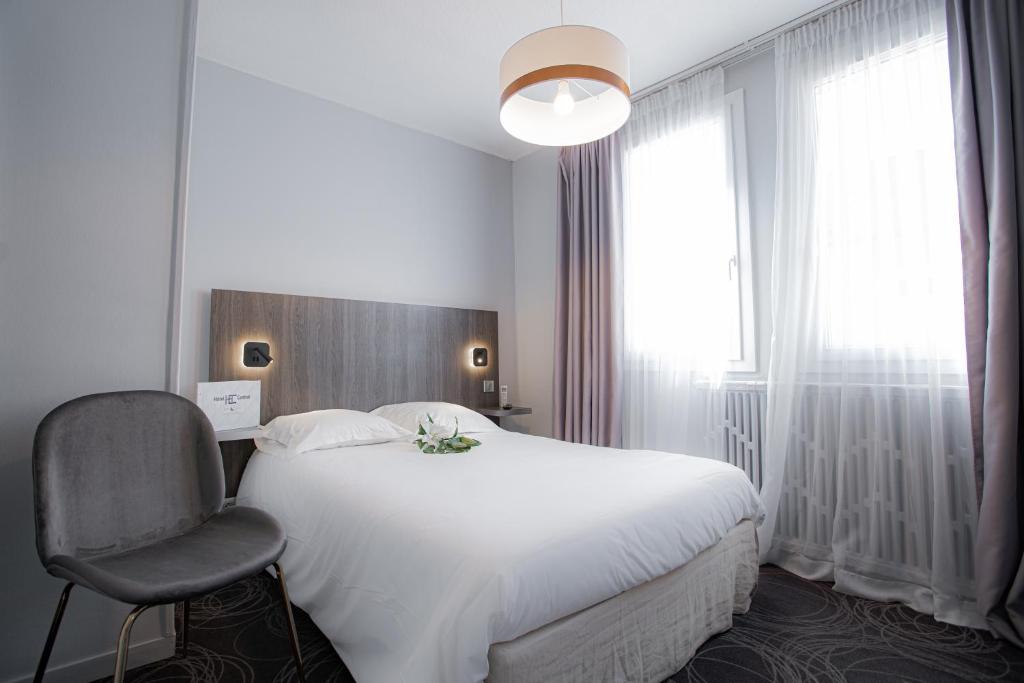 普瓦捷中央酒店的卧室配有白色的床和椅子