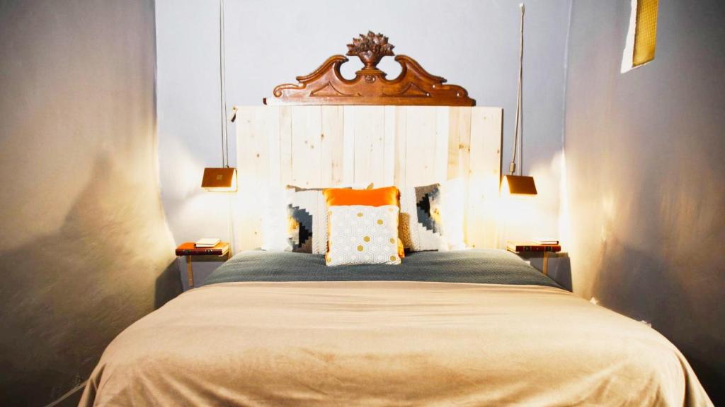 伊泽尔河畔的罗曼Le Bouquiniste, atypique, cosy, fibre, BedinShop的一间卧室配有一张带木制床头板的床