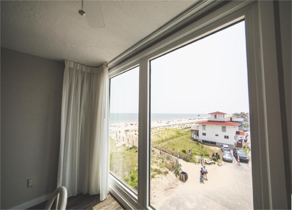 杜威海滩Surf Club Oceanfront Hotel的客房设有可欣赏海滩景致的窗户。