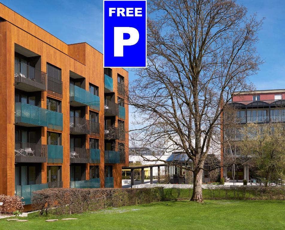 圣加仑Newstar Hotel (Free Parking)的树旁的一座建筑,有免费停车标志