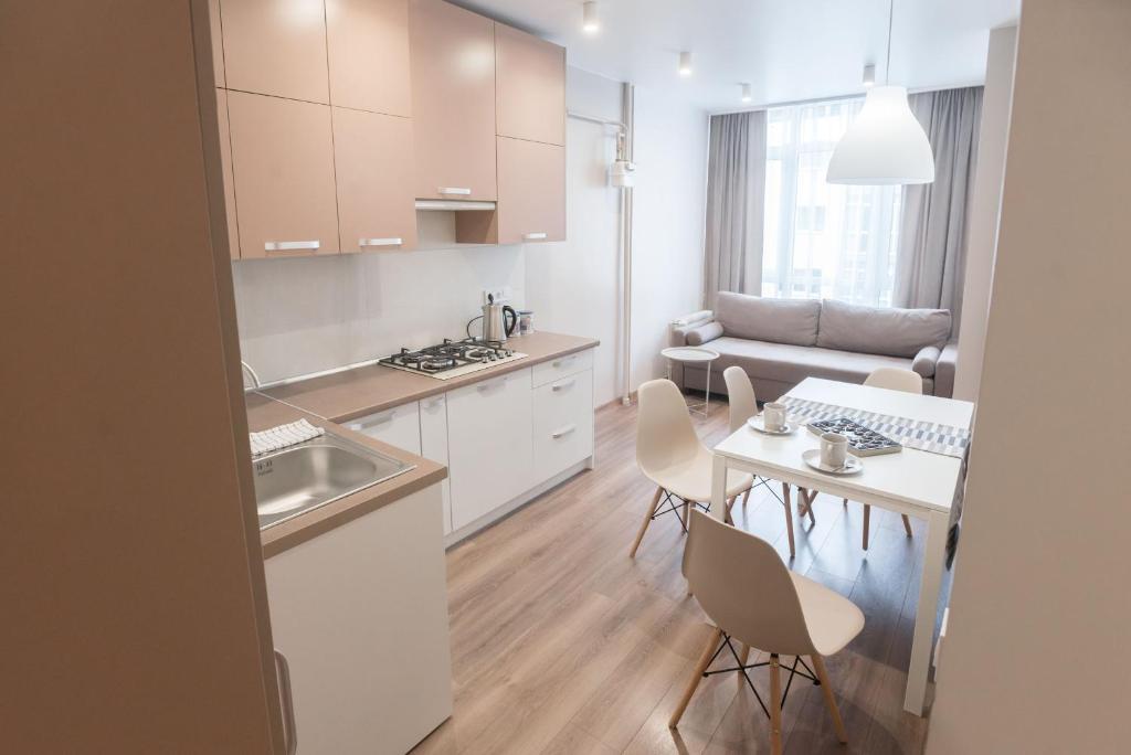 利沃夫Scandinavian apartment Elegant的厨房以及带桌椅的起居室。