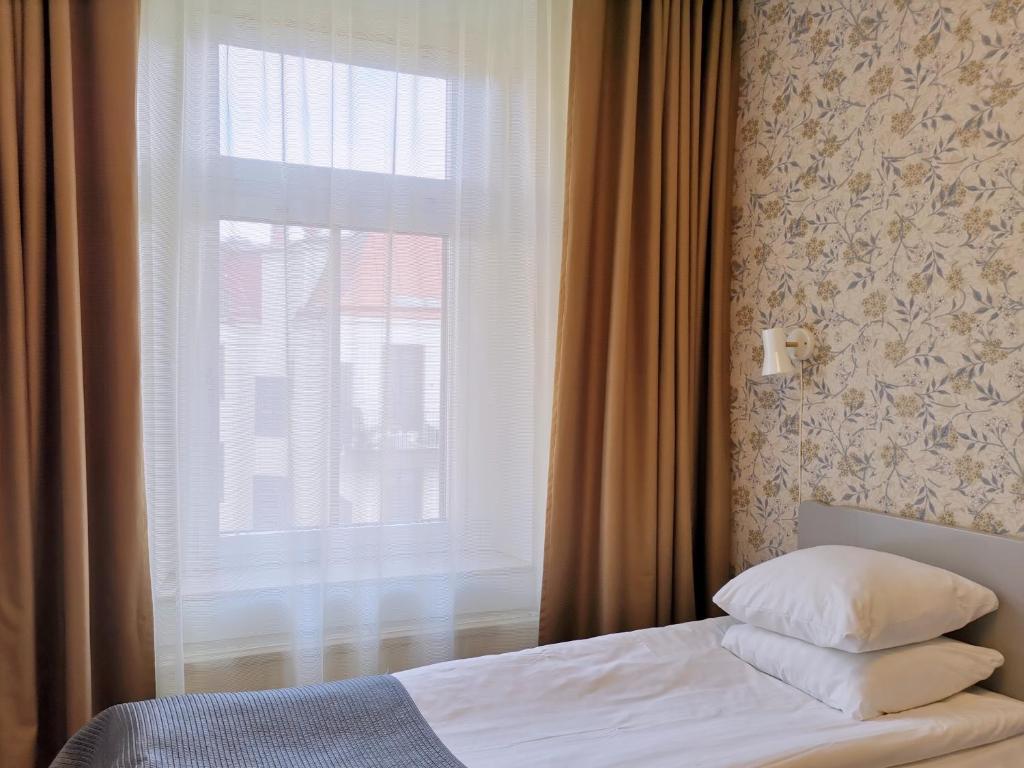 哥德堡Hotel Lorensberg的一间卧室设有一张床和一个窗口