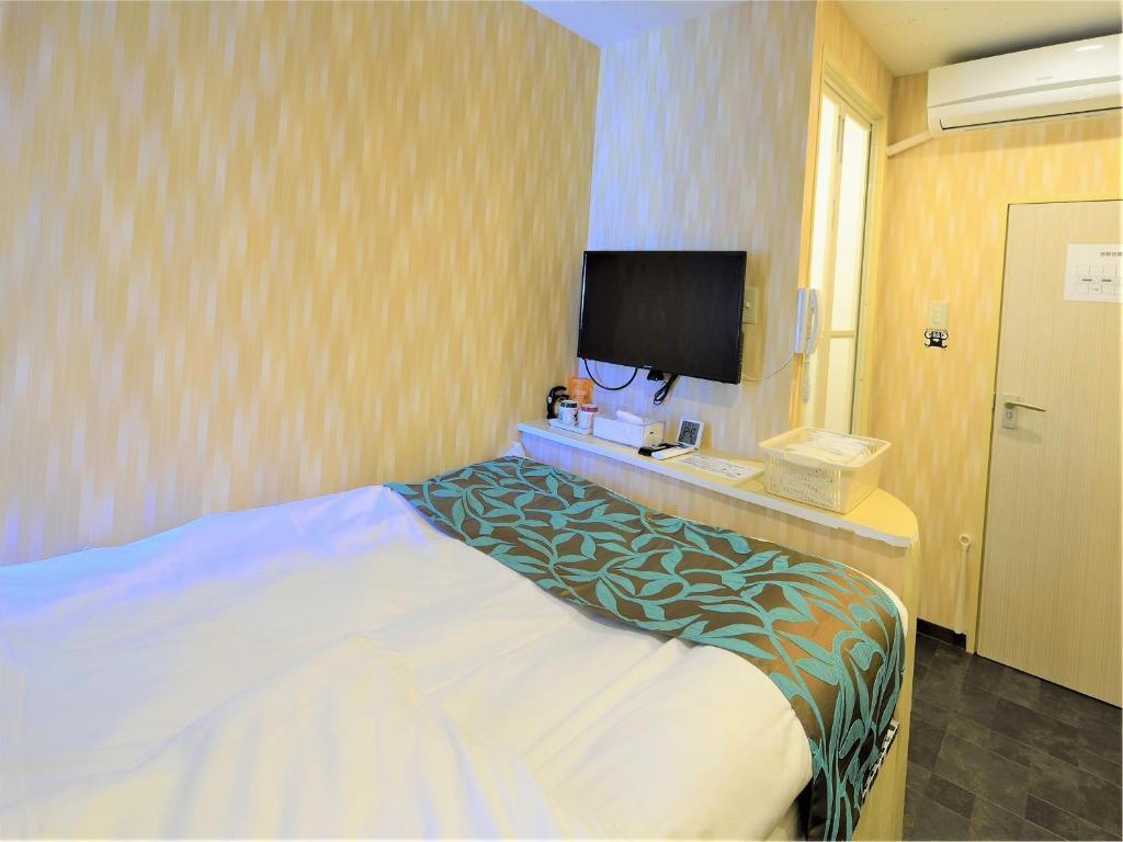 船桥市西船橋駅前 HOTEL的配有一张床和一台平面电视的酒店客房