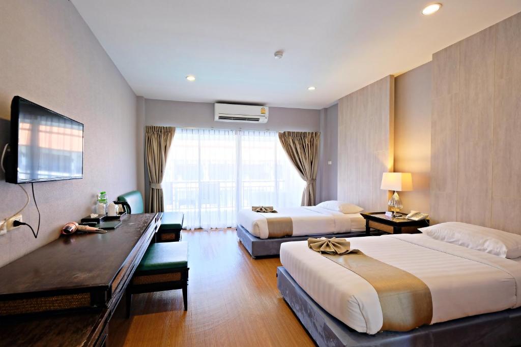 清迈Green Lake Resort - SHA Extra Plus Certified的酒店客房配有两张床和一张书桌