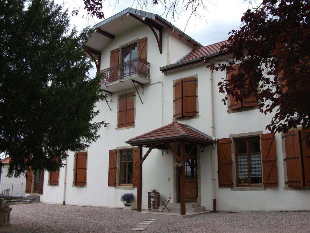 米尔库尔Chambre Hôte Villa Sainte Barbe的白色的大房子,设有木窗和门