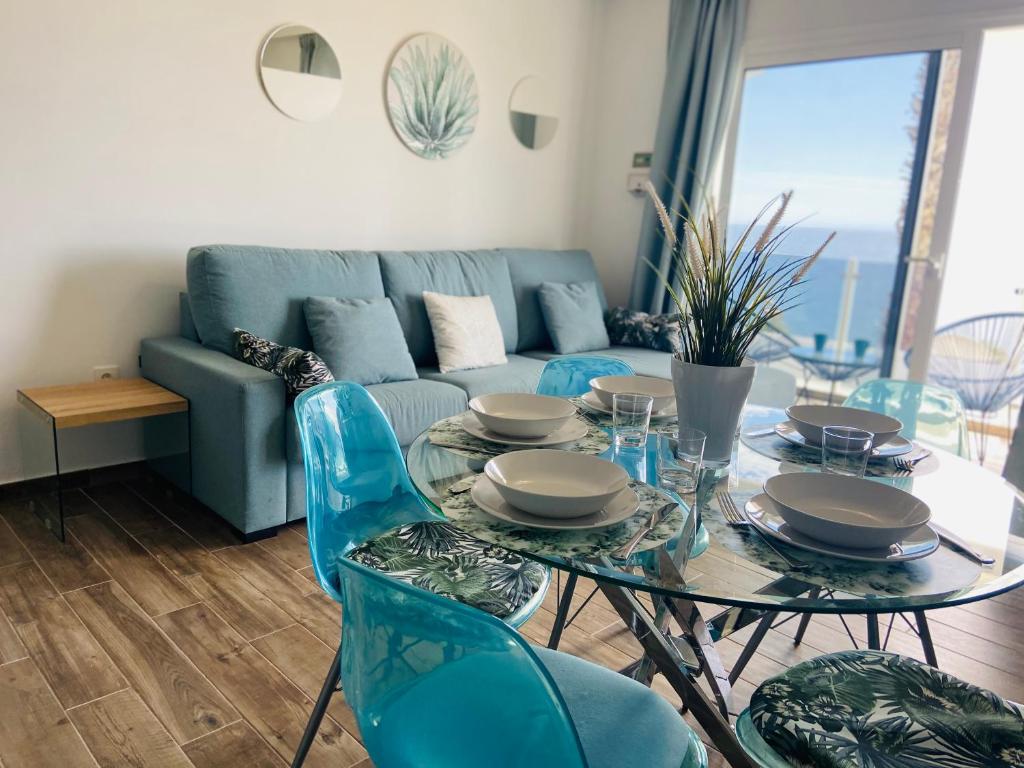 卡门港Sabbia Suites Yemayá的客厅配有桌椅和沙发