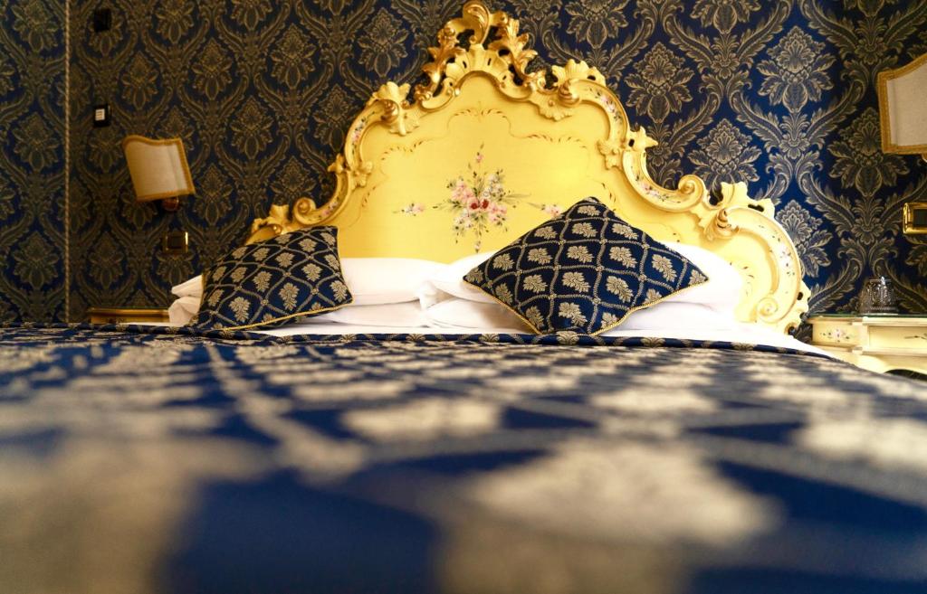 威尼斯Ca' Morosini 1 & 2的一间卧室配有蓝色和金色的床和枕头