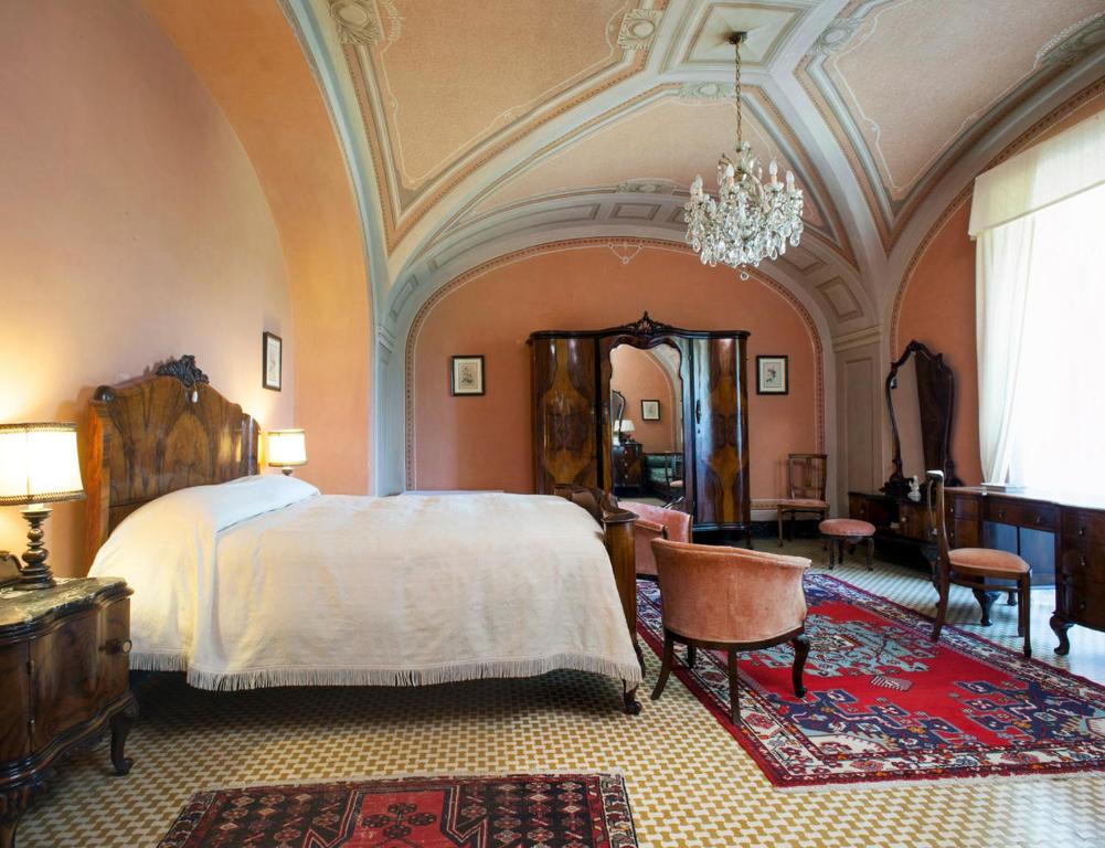维泰博法里内拉别墅旅馆的一间卧室配有一张大床和一个吊灯。
