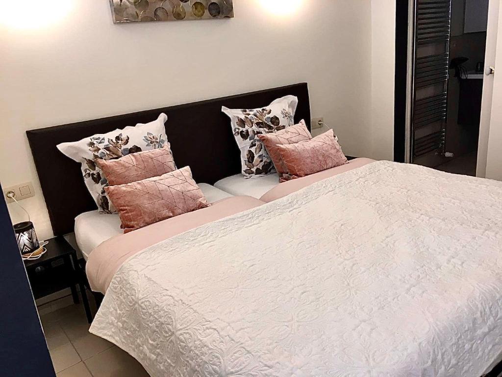 拉罗什-阿登Nocturno的一间卧室配有带粉色和白色枕头的床