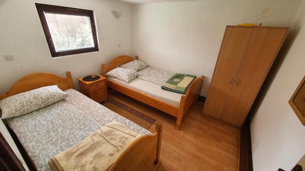 兹拉蒂博尔AB Apartments的一间小卧室,配有两张床和窗户
