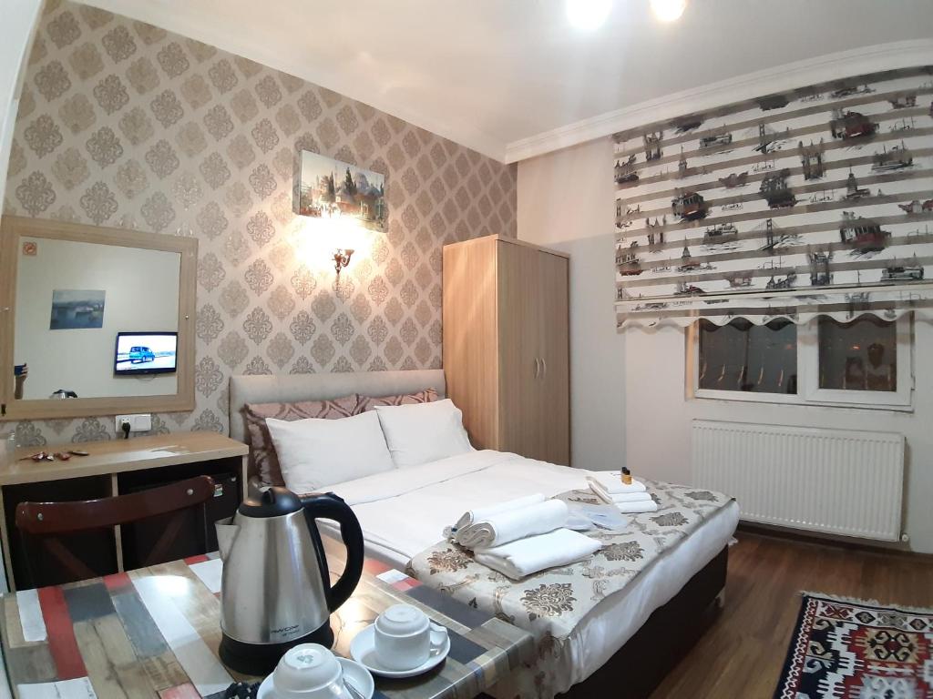 伊斯坦布尔Burak Apart的一间卧室配有一张床、一张桌子和茶壶
