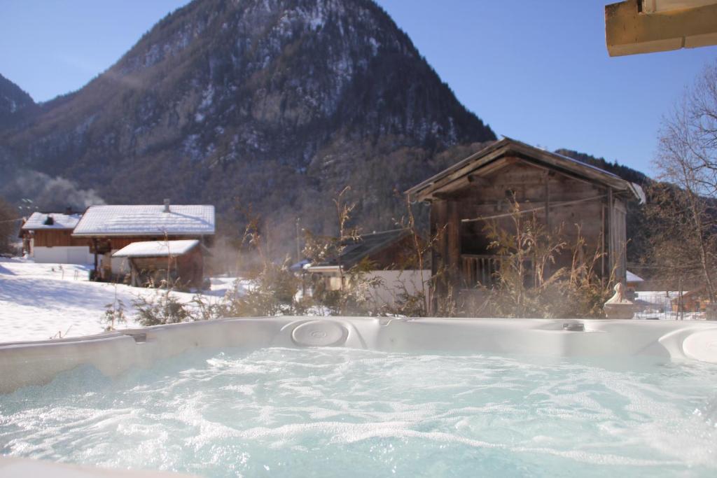 西克斯特巴尔尼奥拉波米迪品度假屋的山前雪地中的热水浴池