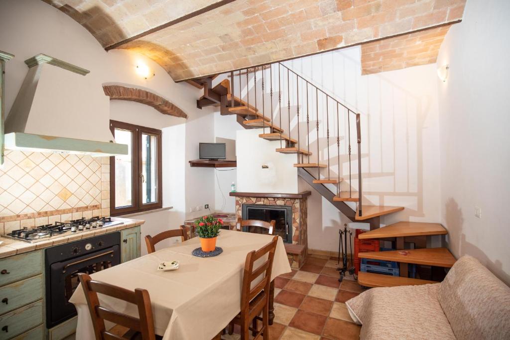 Isola del GiglioCasaMatta2的厨房以及带桌子和楼梯的用餐室。