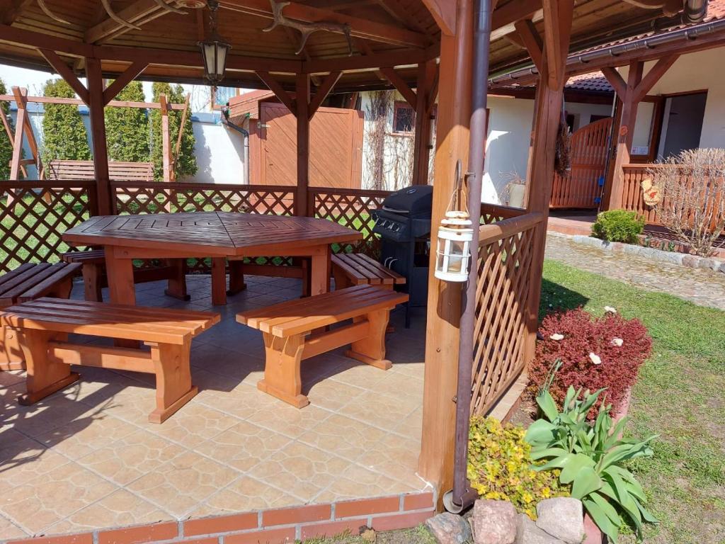 科乌切沃Apartamenty Kołczewo的木制凉亭配有野餐桌和长凳
