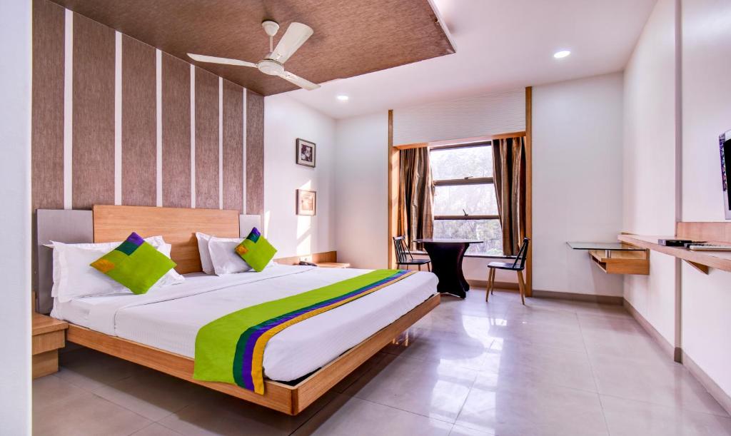奥兰加巴德Treebo Trend Admiral Suites New Usmanpura的一间卧室,卧室内配有一张大床