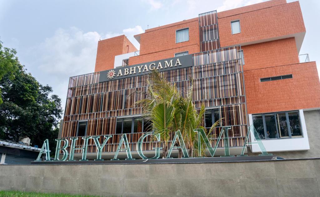迪卡Abhyagama Hotel的砖砌的建筑,上面有读过比利亚尼亚马的标志