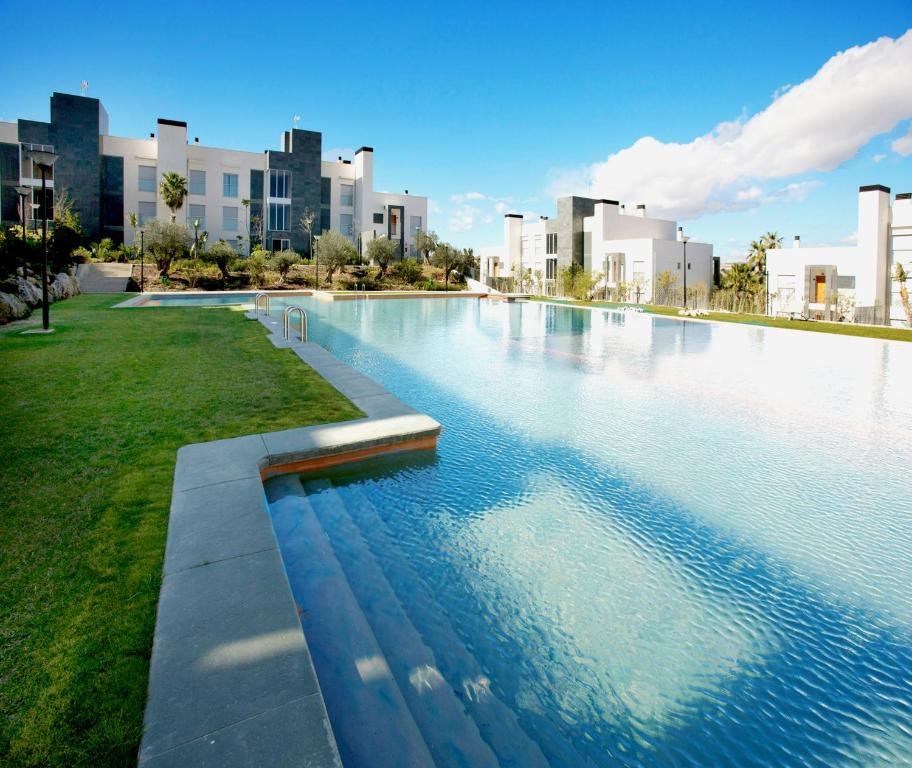 阿利坎特种植园高尔夫度假酒店的一座位于城市的游泳池,有高大的建筑