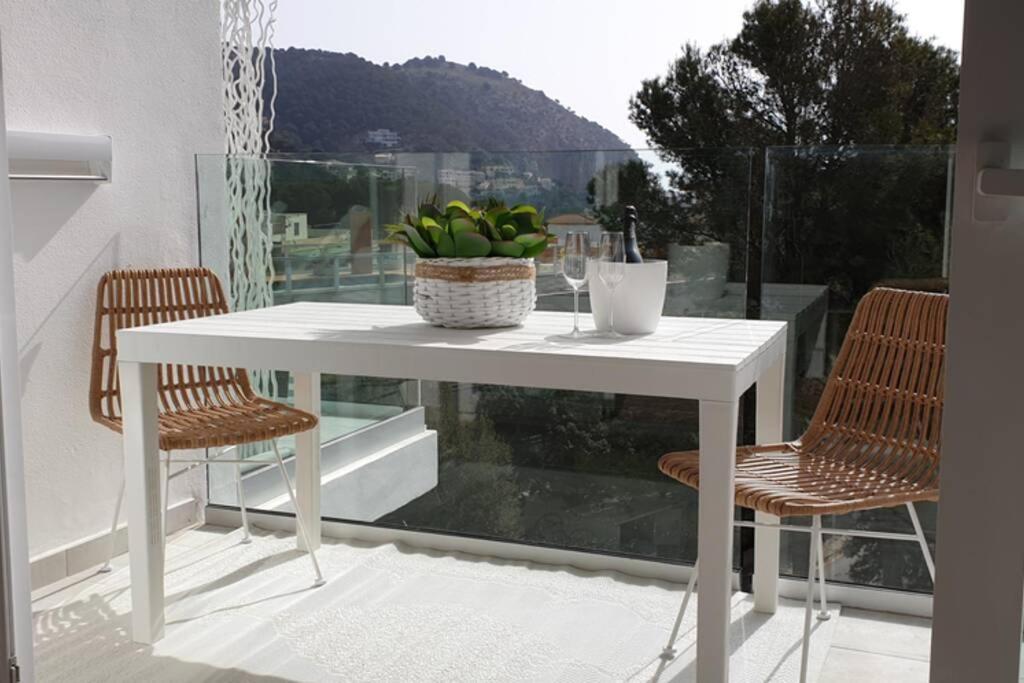 卡普德佩拉Apartment Sa Calobra with pool & terrace in Canyamel的阳台上配有一张白色的桌子和两把椅子