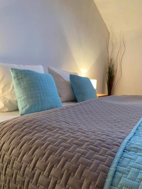 布雷兹诺Apartmán Ivka的一间卧室配有一张带蓝色和白色枕头的床