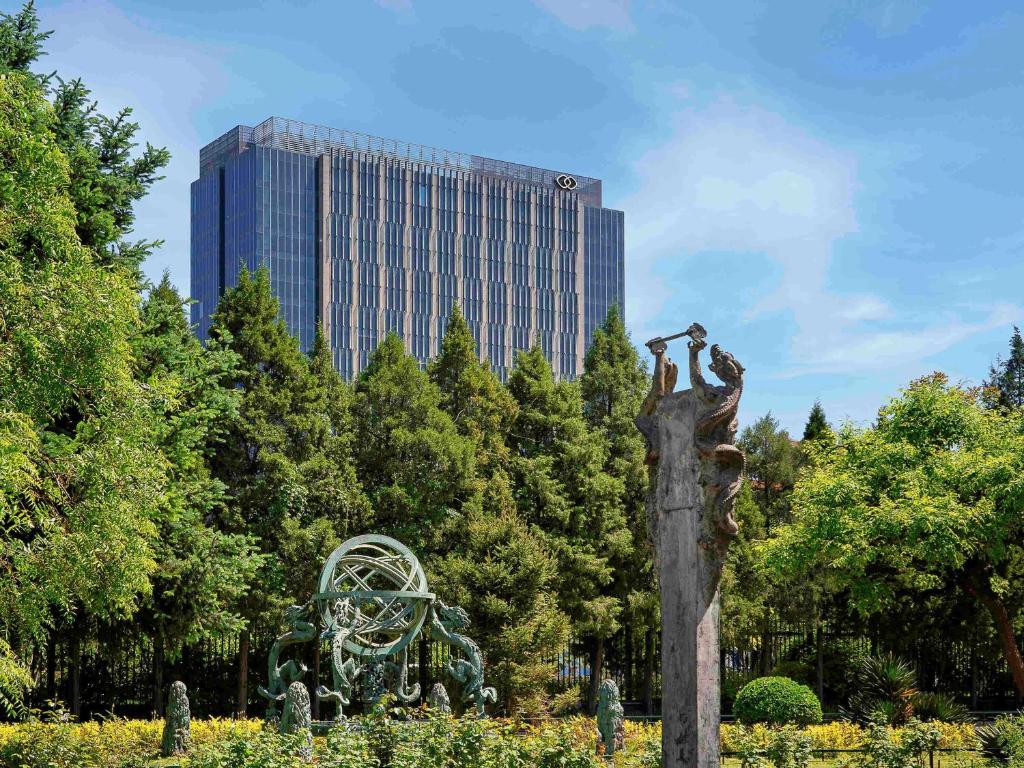 北京北京索菲特大酒店的一座建筑背景公园中的雕像