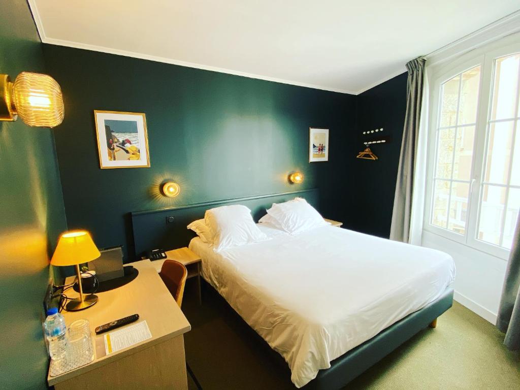 迪纳尔Hotel du Parc的一间卧室配有一张床和一张带床头柜的书桌