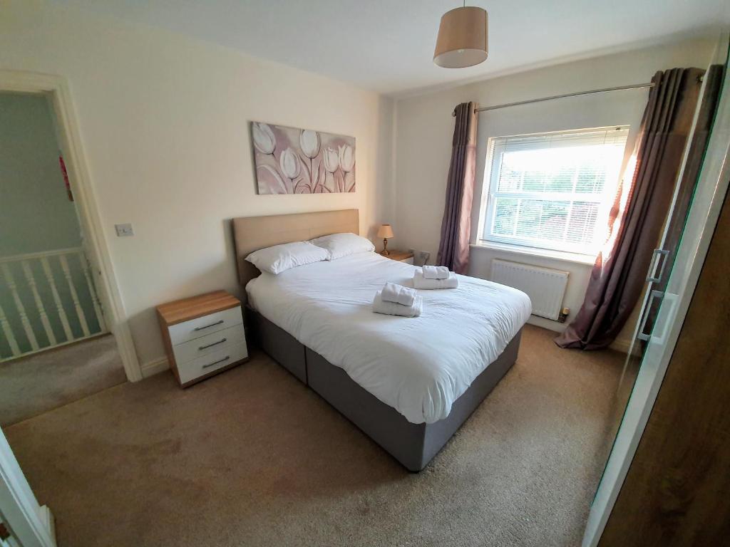 贝弗利Beverley Central Townhouse Free Parking Sleeps 8的一间卧室配有一张带白色床单的床和一扇窗户。