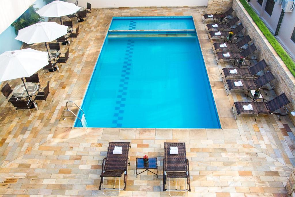 塞拉内格拉塞拉内格拉皇宫酒店的享有带椅子和遮阳伞的游泳池的上方景色