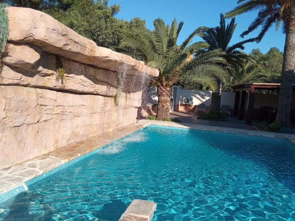 德尼亚Apartamentos Montgò的棕榈树度假村内的游泳池