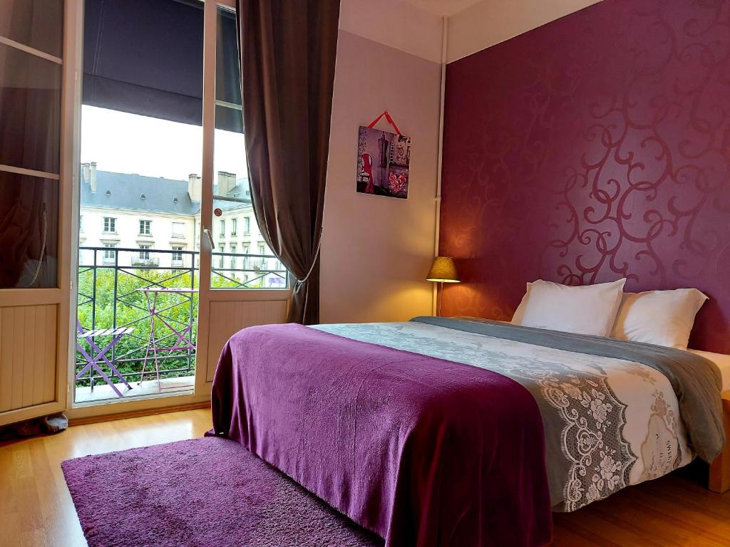 图尔蒙迪尔酒店的一间卧室配有一张紫色墙壁的床