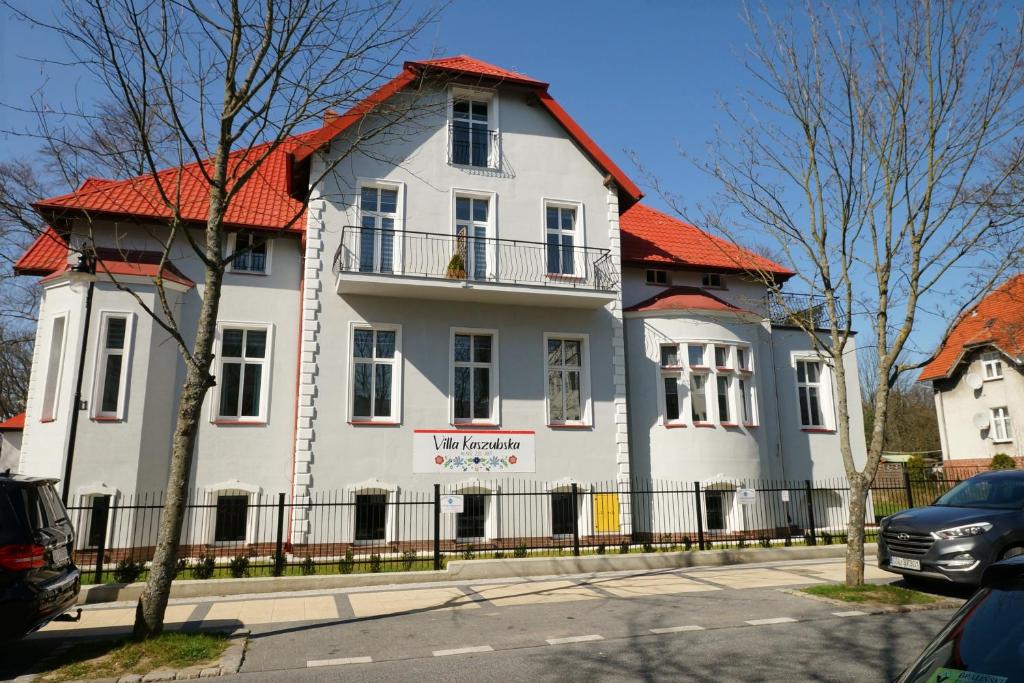 乌斯特卡Villa Kaszubska的一座白色的大房子,有橙色的屋顶