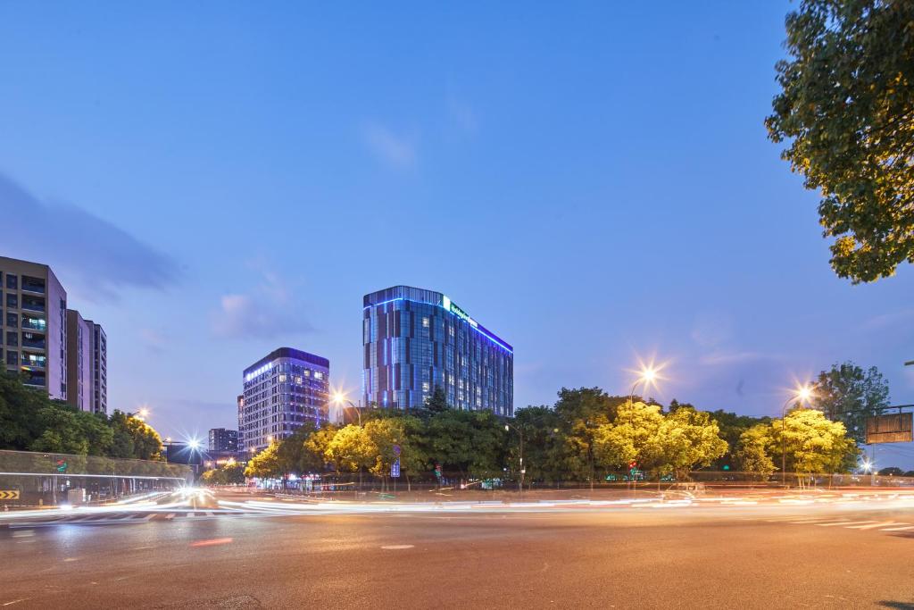杭州杭州九州智选假日酒店的一条城市街道,晚上有高大的建筑
