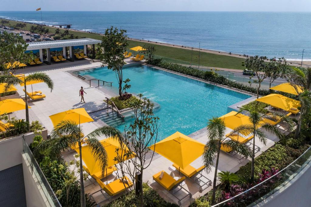 科伦坡Shangri-La Colombo的享有游泳池的顶部景致,配有黄色遮阳伞