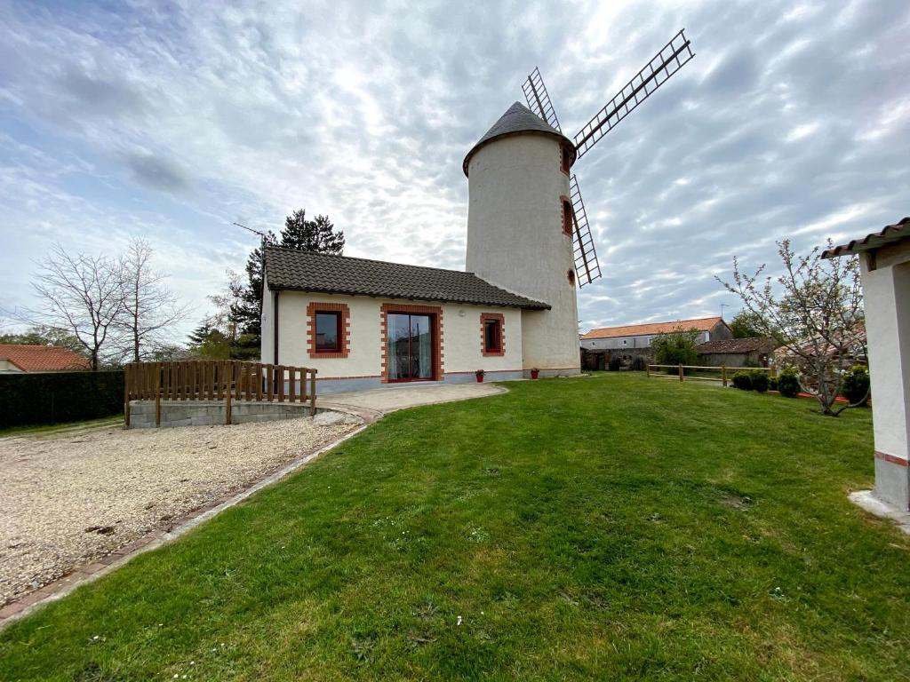 Saint-Georges-du-Puy-de-la-GardeLE MOULIN DES GARDES的院子里有风车的房子
