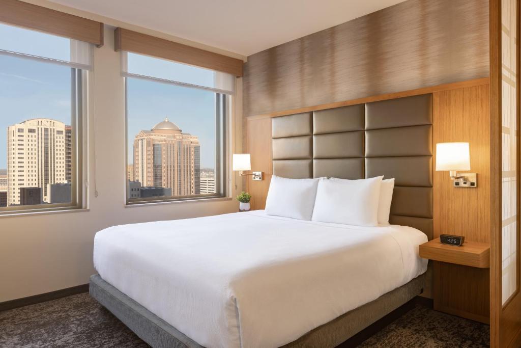 休斯顿Hyatt Place Houston Downtown的卧室设有白色大床和窗户。