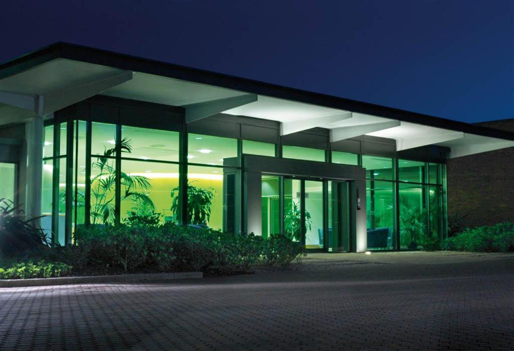 霍舍姆Roffey Park Institute的一座大型建筑,晚上设有玻璃窗