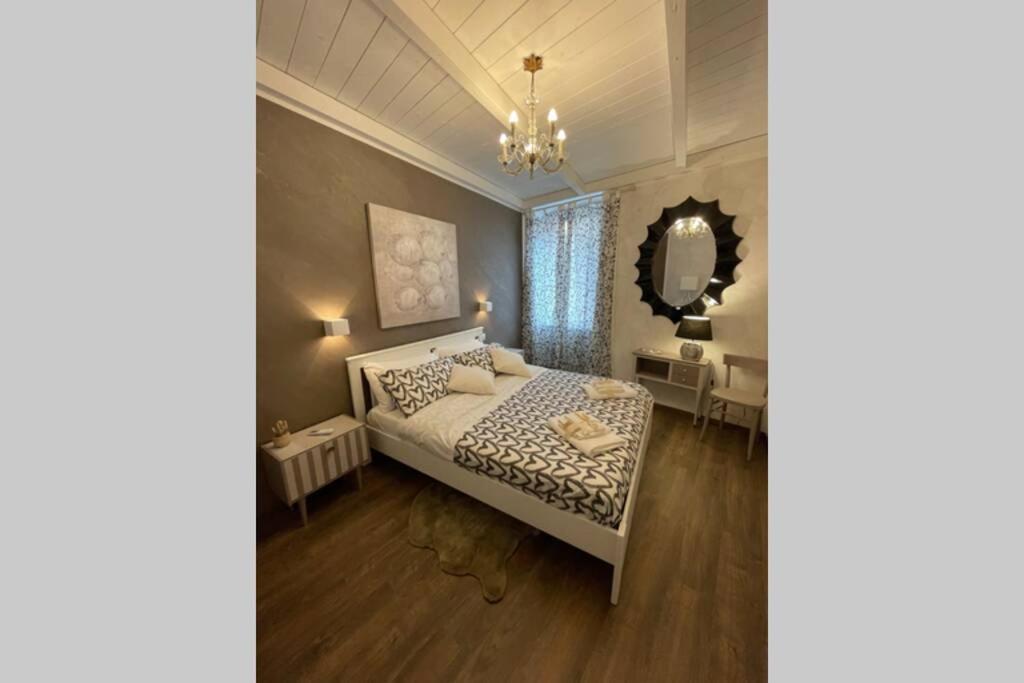 维泰博DOMUS TUSCIA APARTMENTS Via Estrema 2的一间卧室配有一张床和一面大镜子