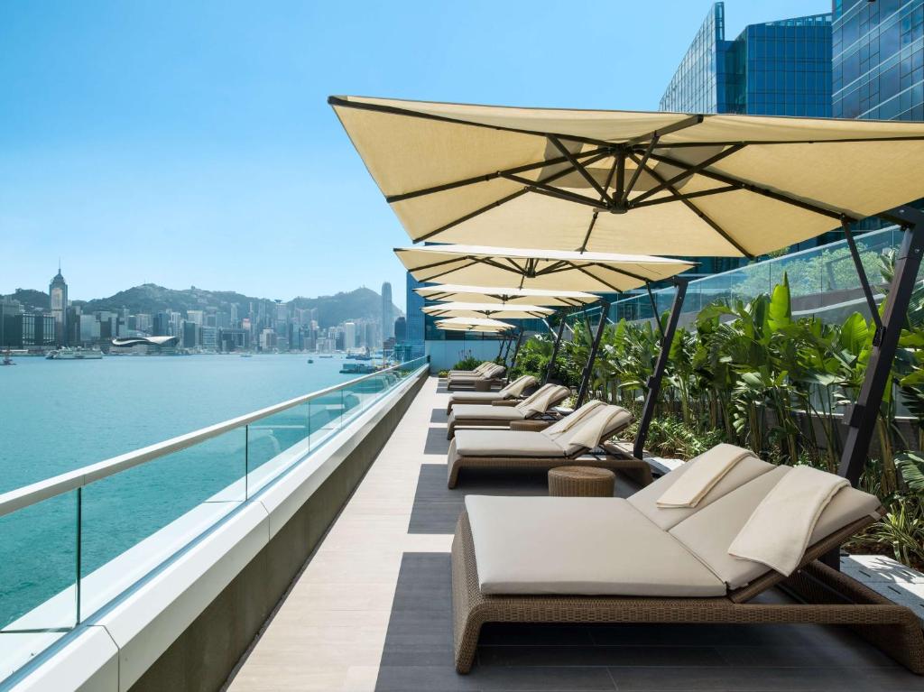 香港香港嘉里酒店的阳台上的一排躺椅和遮阳伞